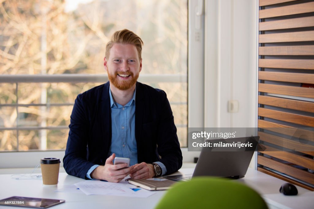 Junge Manager lächelnd in seinem Büro