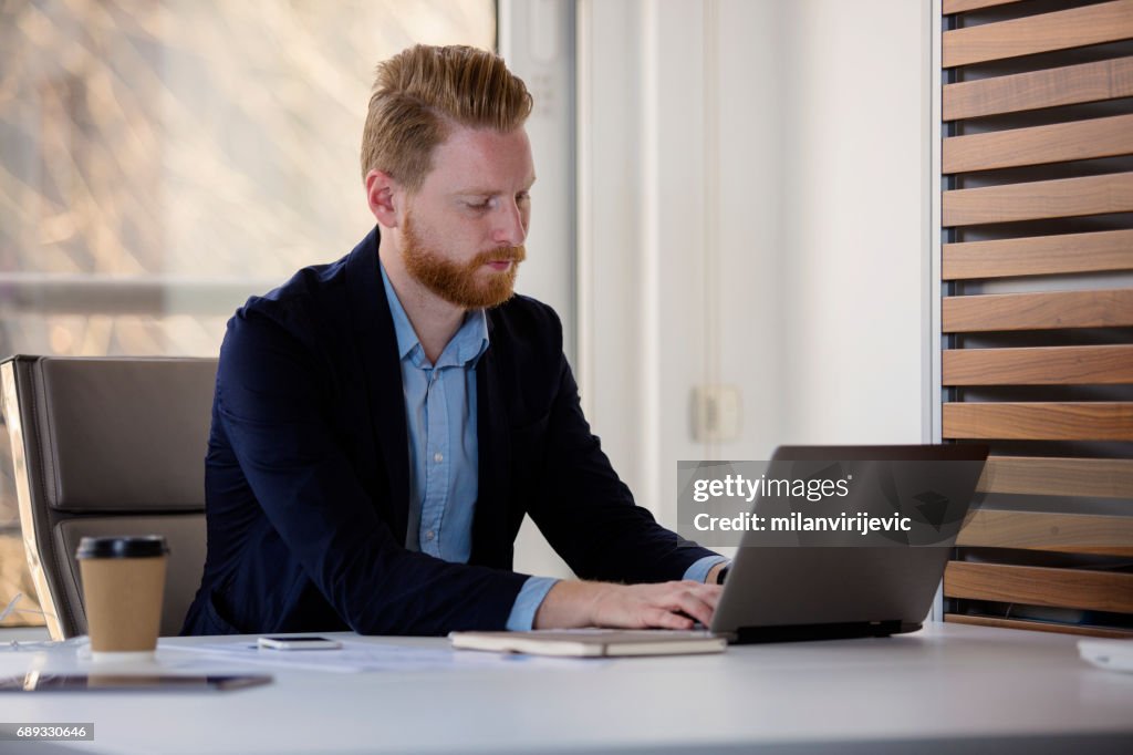 Jovem Empresário trabalhando no laptop