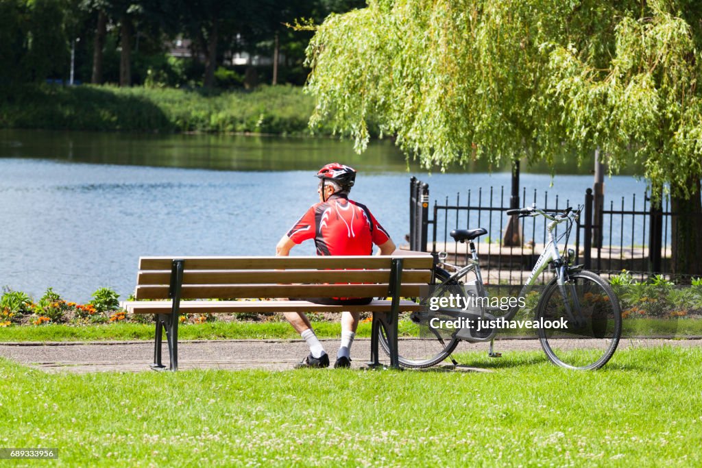 Senior man in sports dress relaxing on bench at Ruhr