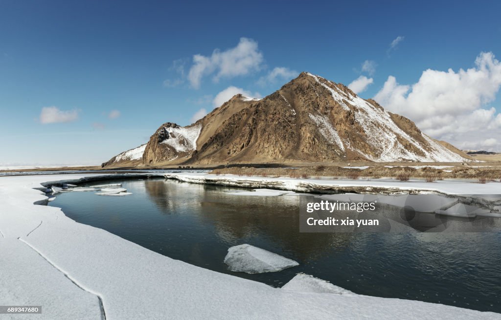 Frozen lake surrounded by snow on Bayanbulak,China