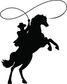 Cowboy silhouette with lasso on horse