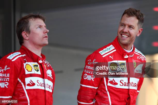 Sebastian Vettel of Germany and Ferrari celebrates his race win on the podium next to Kimi Raikkonen of Finland and Ferrari during the Monaco Formula...