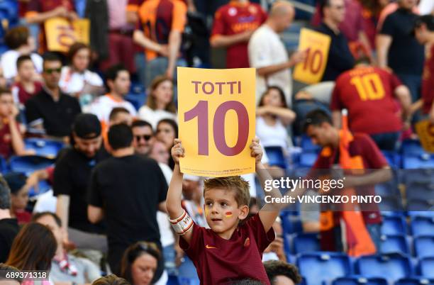 Young football fan shows a poster "Totti 10" in honor of AS Roma's number 10 Francesco Totti before the Italian Serie A football match AS Roma vs...