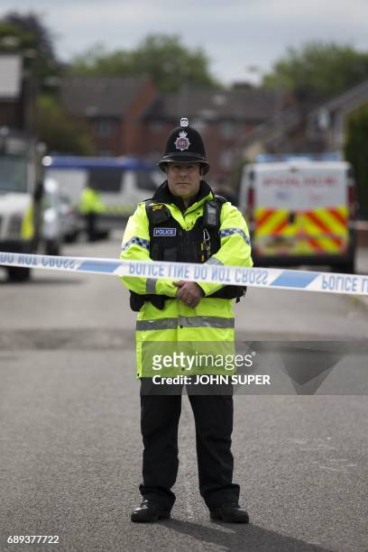 Police officer guards the entrance to a street in the Moss Side area of Manchester on May 28, 2017 during an operation. - A British minister said...