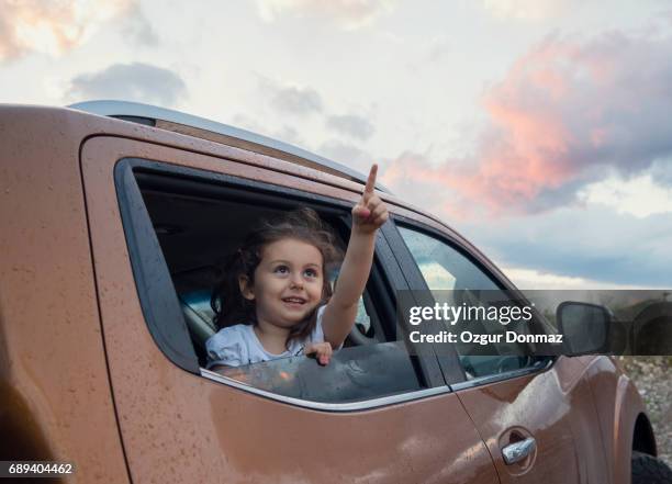 little girl leans out car window - conveyor belt point of view stockfoto's en -beelden