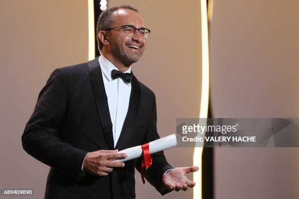 Russian director Andrey Zvyagintsev smiles on stage after he was awarded with the Jury Prize for the film 'Loveless' on May 28, 2017 during the...