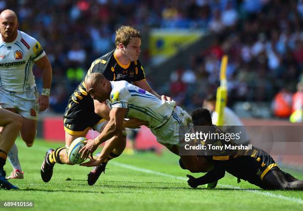 Joe Launchbury and Christian Wade of Wasps tackle Olly Woodburn of Exeter Chiefs during the Aviva Premiership Final match between Wasps and Exeter...