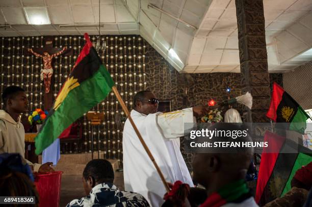 Father Charles Ubawuike blesses members of the parish, while waving the Biafran flag, during a service at the St. Martin Catholic of Tours Church on...