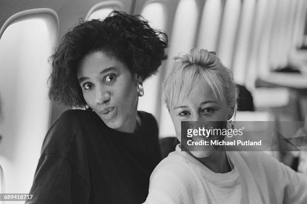 Backing singers Pepsi and Shirlie on board an airliner during 'The Big Tour', with British pop duo Wham!, 1985. Left to right: Helen DeMacque and...