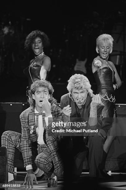 Andrew Ridgeley and George Michael of Wham! performing during the pop duo's 1985 world tour, January 1985. In the background are backing singers...