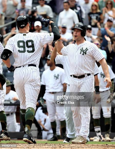 Matt Holliday of the New York Yankees celebrates with teammate Aaron Judge after Judge drove them all home with a grand slam in the third inning...