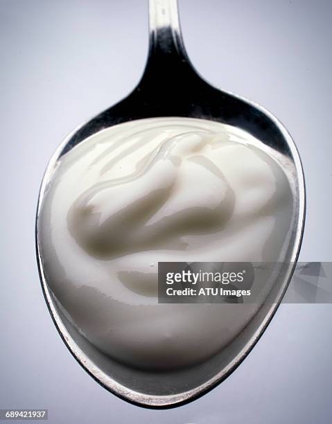 yogurt on spoon - yogurt spoon stock-fotos und bilder