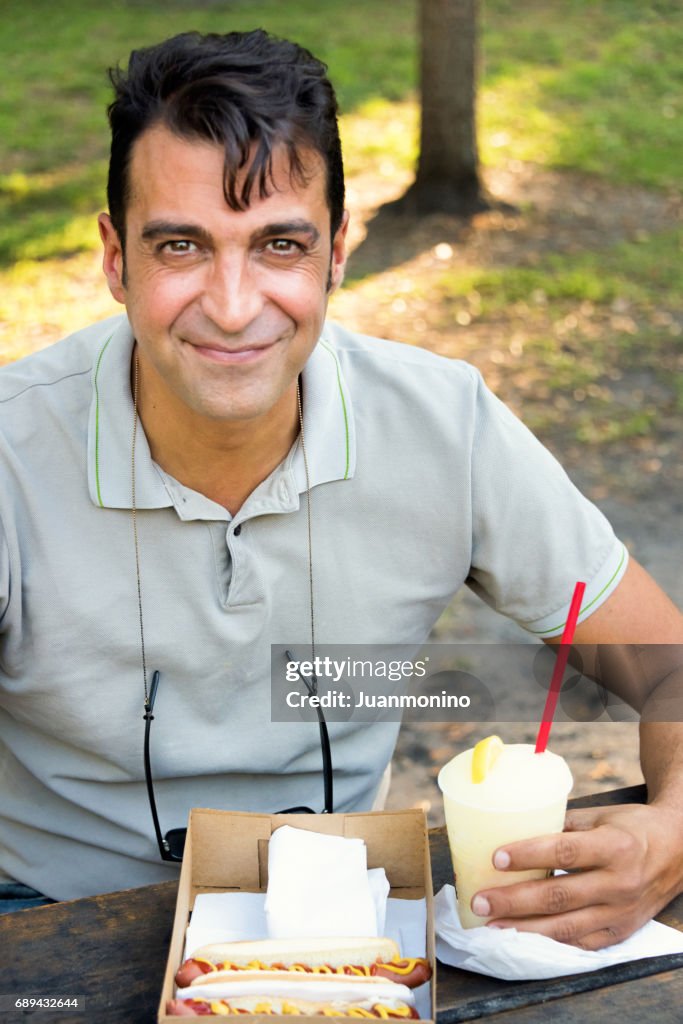 Lächelnde reifer Mann dem Mittagessen in einem park