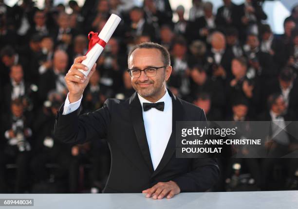 Russian director Andrey Zvyagintsev poses on May 28, 2017 during a photocall after he won the Jury Prize for his film 'Loveless' at the 70th edition...