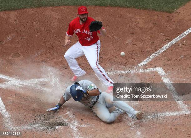 Elvis Andrus of the Texas Rangers scores on a wild pitch as Dominic Leone of the Toronto Blue Jays covers home plate in the seventh inning during MLB...