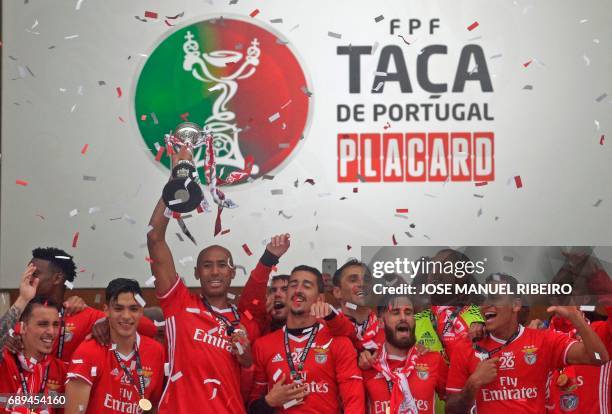 Benfica captain Brazilian defender Luisao holds up the cup to celebrate with teammates after winning the Portugal's Cup at the end of the final...