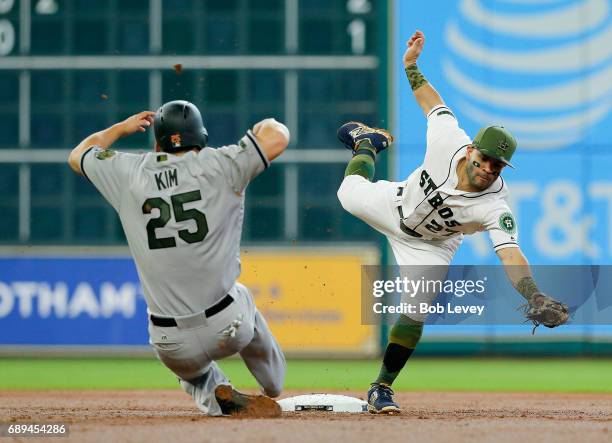 Jose Altuve of the Houston Astros reaches for the ball as Hyun Soo Kim of the Baltimore Orioles slides into second base in the second inning at...