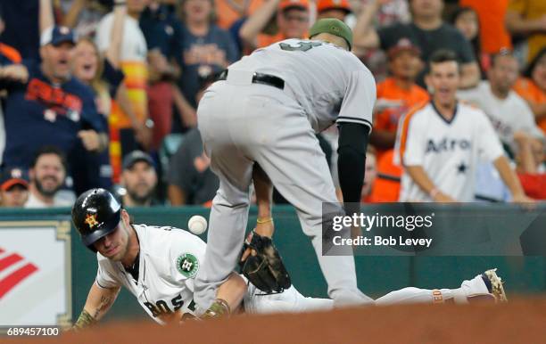 Josh Reddick of the Houston Astros triples in the second inning as Manny Machado of the Baltimore Orioles bobbles the throw at Minute Maid Park on...