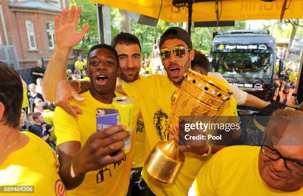 Ousmane Dembele, Sokratis Papastathopoulos and Pierre-Emerick Aubameyang of Borussia Dortmund lift the DFB Cup trophy as the team celebrates during a...