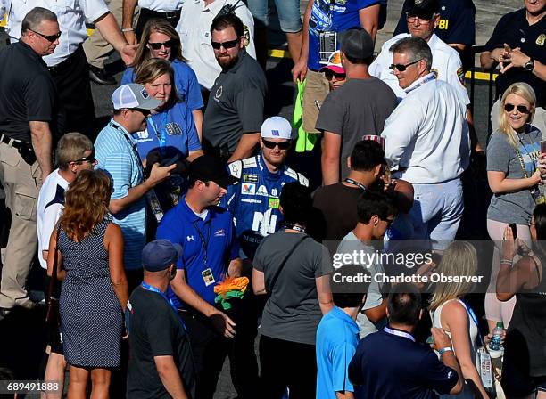 Driver Dale Earnhardt Jr., center, becomes a face in the crowd as he walks to his car on pit road during pre-race festivities for the Coca-Cola 600...