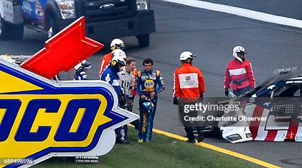 Drivers Brad Keselowski, left, and Chase Elliott, right, talk as they walk to an ambulance following a wreck heading into Turn 1 at Charlotte Motor...