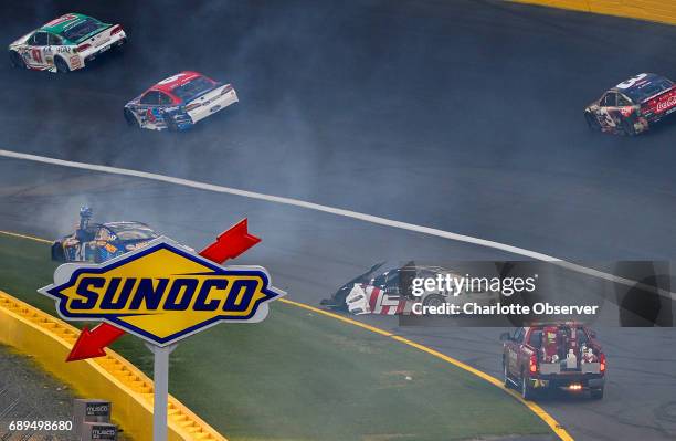 Drivers Chase Elliott, left, watches from the door frame of his car as Brad Keselowski, right, heads toward him during a wreck heading into Turn 1 at...