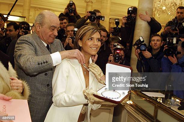 Harrods department store owner Mohamed Al Fayed and singer Victoria Beckham show off the most expensive item in the Harrods Winter Sale, January 2,...