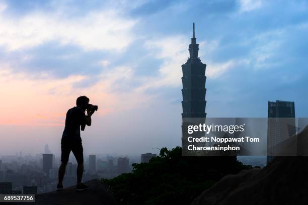 male traveler shooting taipei 101, taipei, taiwan - taipeh gegenlicht stock-fotos und bilder