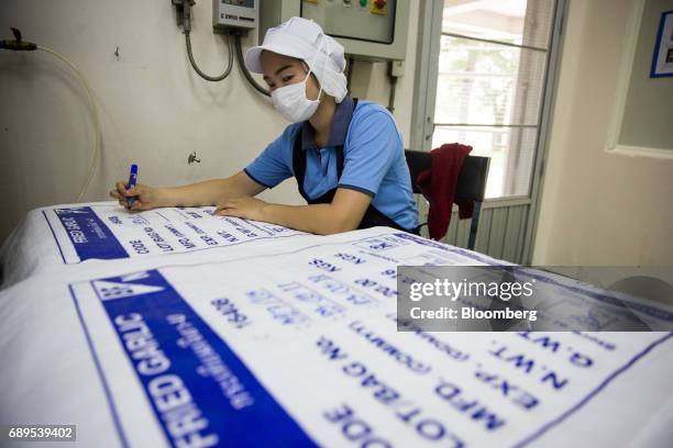 An employee labels bags of fried garlic at the Nithi Foods Co. Factory in the San Pa Tong district of Chiang Mai, Thailand, on Tuesday, May 23, 2017....