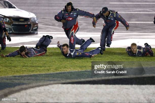 Austin Dillon, driver of the DOW Salutes Veterans Chevrolet, and his crew slide in the infield grass in celebration of winning the Monster Energy...