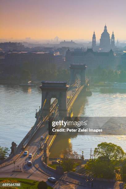 the chain bridge of budapest at sunrise with the st. stephen's basilica in the background - basilica of st stephen budapest stock pictures, royalty-free photos & images