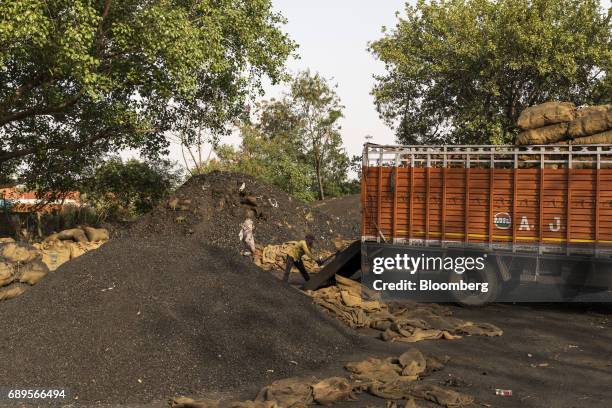 Workers unload coal from a truck at a wholesale supplier's in New Delhi, India, on Sunday, May 28, 2017. India's ailing electricity distributors may...