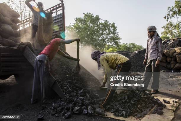 Workers unload coal from a truck at a wholesale supplier's in New Delhi, India, on Sunday, May 28, 2017. India's ailing electricity distributors may...