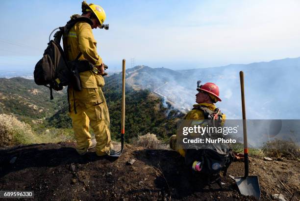 Firefighters watch a wildfire burning in Mandeville Canyon in Los Angeles, California on May 28, 2017. More than 150 firefighters battle the fire...