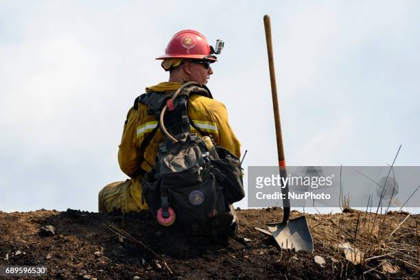 Firefighter watches a wildfire burning in Mandeville Canyon in Los Angeles, California on May 28, 2017. More than 150 firefighters battle the fire...