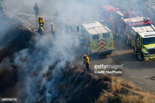 Firefighters battle a wildfire in Mandeville Canyon in Los Angeles, California on May 28, 2017. More than 150 firefighters battle the fire that burns...