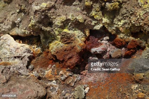 Hardened lava cloured by sulphur and minerals lies under the peak of Mount Etna on the island of Sicily on May 28, 2017 near Catania, Italy. Mount...