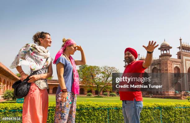 two female visitors on a tour at the taj mahal - indian tour guide stock pictures, royalty-free photos & images