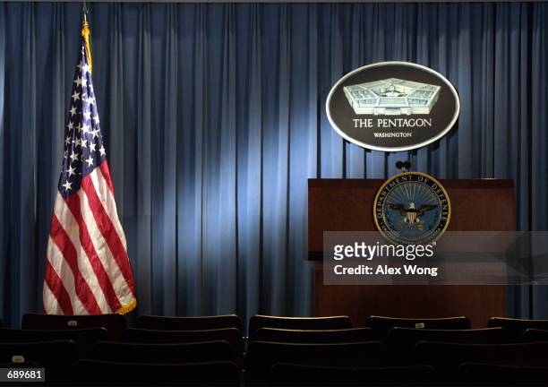 The Pentagon logo and an American flag are lit up January 3, 2002 in the briefing room of Pentagon in Arlington, VA.