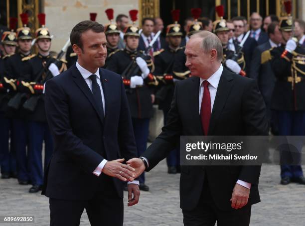 French President Emmanuel Macron greets Russian President Vladimir Putin duirng their meeting in Versailles, France, May 2017. Vladimir Putin is...