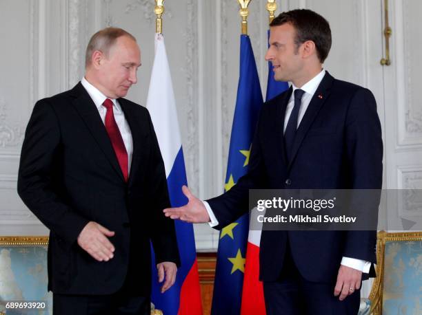 French President Emmanuel Macron greets Russian President Vladimir Putin duirng their meeting in Versailles, France, May 2017. Vladimir Putin is...