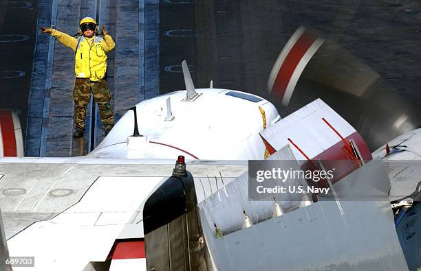 Aviation Boatswains Mate 3rd Class Krystol Koos directs a C-2 "Greyhound" aircraft to the bow catapults for launch during flight operations December...