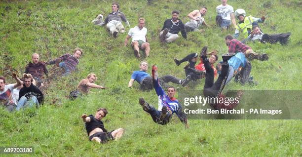 Chris Anderson wins the first race during the annual unofficial cheese rolling at Cooper's Hill in Brockworth, Gloucestershire, where a cheese has...