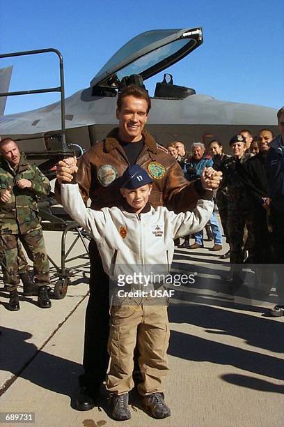 Actor Arnold Schwarzenegger and his son, Patrick, pose in front of an F-22 Raptor with airmen in this undated recent photo at Edwards Air Force Base...