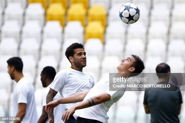 Juventus' forward Paulo Dybala from Argentina and Juventus' defender Daniel Alves from Brazil attend the training session during the Media Day prior...