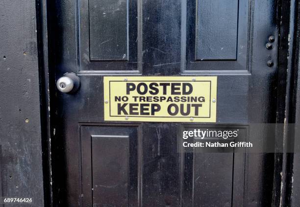 keep out sign posted on black door - keep out sign stock pictures, royalty-free photos & images
