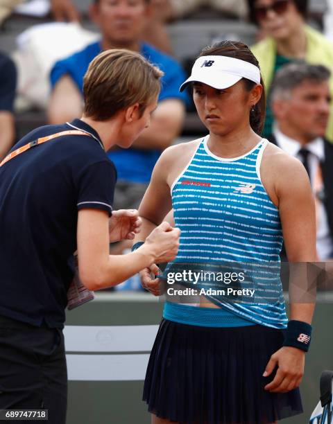 Misaki Doi of Japan is treated by a traier following an injury during the ladies singles first round match against Sara Errani of Italy on day two of...