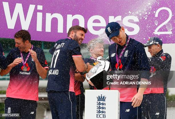 England's Eoin Morgan is sprayed with champagne as he poses with the trophy after England won their One-Day International series, at the end of the...