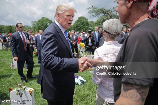 President Donald Trump shakes hands with Jim Malachowski of Westminster, Maryland, while walking through Section 60 at Arlington National Cemetery on...