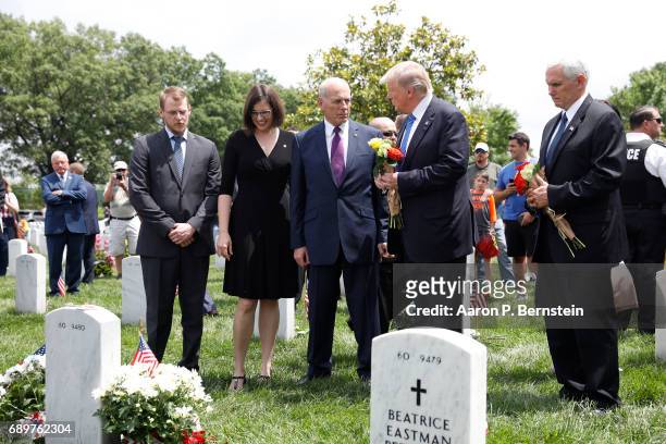 President Donald Trump speaks with Secretary of Homeland Security John Kelly and Vice President Mike Pence before laying flowers on the grave of...